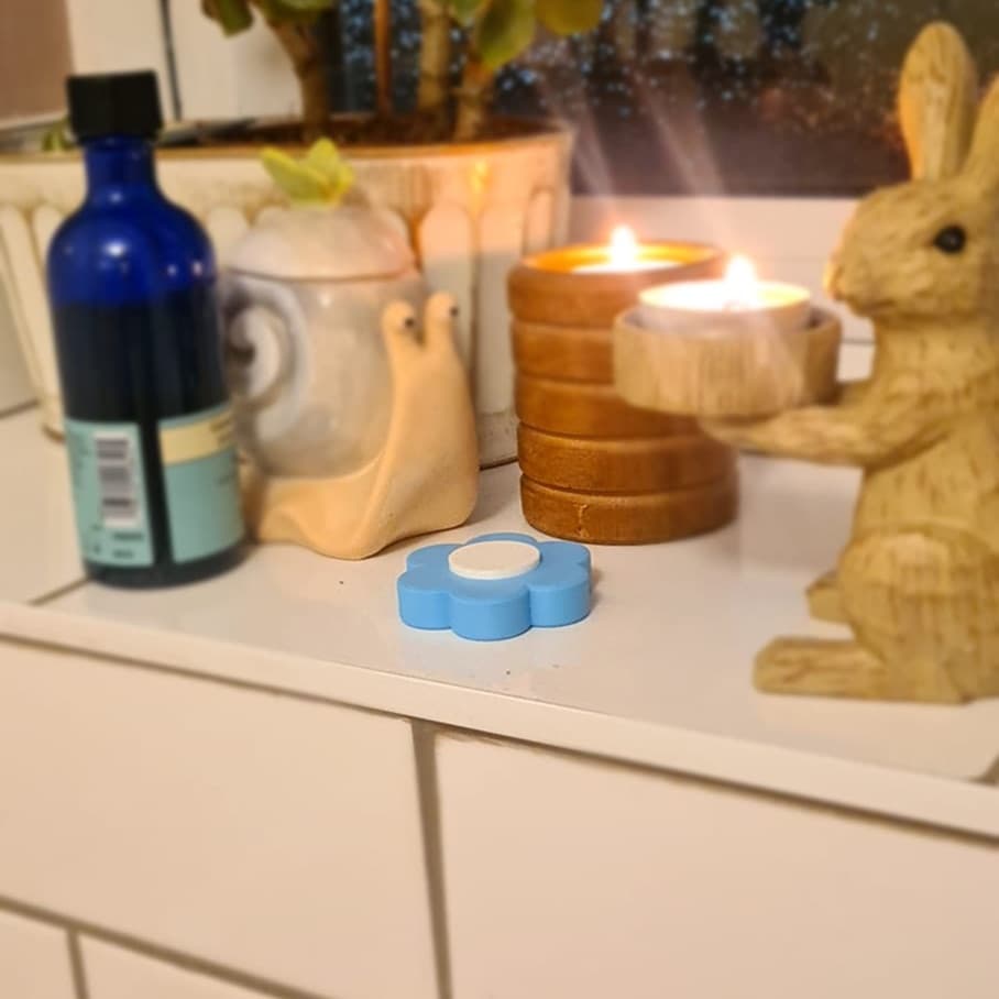 Blue Faerd Lock Charm on a shelf with candles and plants